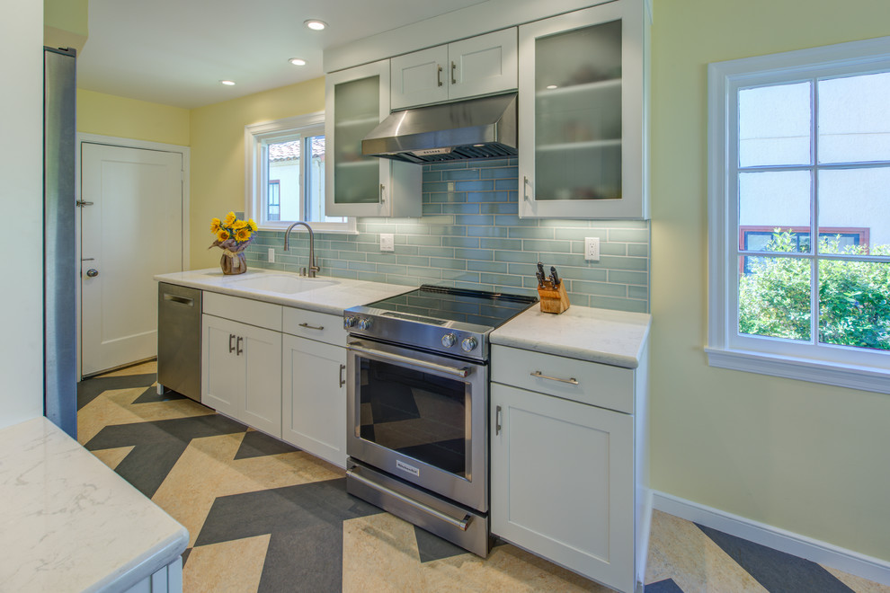 Photo of a small traditional galley separate kitchen in San Francisco with a single-bowl sink, shaker cabinets, white cabinets, quartz benchtops, blue splashback, ceramic splashback, stainless steel appliances, linoleum floors and no island.