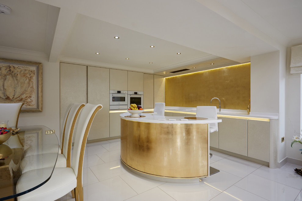 This is an example of a contemporary l-shaped open plan kitchen in Other with flat-panel cabinets, beige cabinets, metallic splashback, glass sheet splashback, with island and white floor.
