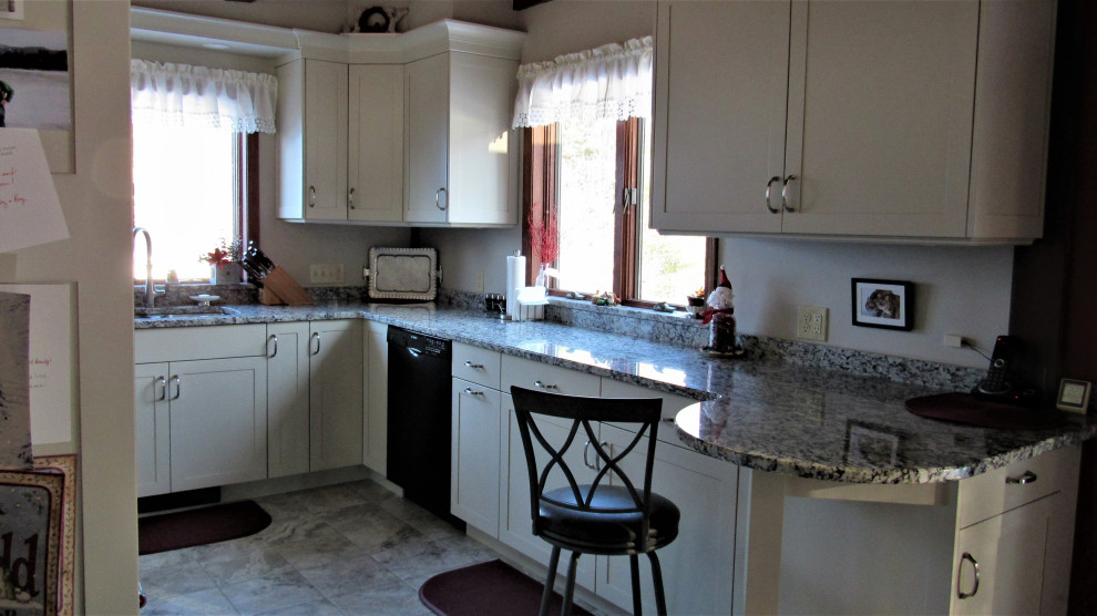 Example of a mid-sized transitional u-shaped eat-in kitchen design in Boston with an undermount sink, shaker cabinets, beige cabinets, granite countertops, stainless steel appliances, a peninsula and gray countertops