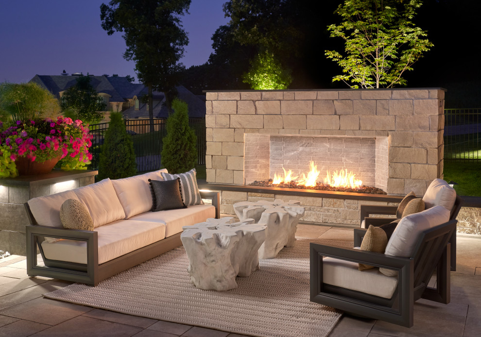 This is an example of a contemporary backyard garden in Minneapolis with with fireplace and natural stone pavers.