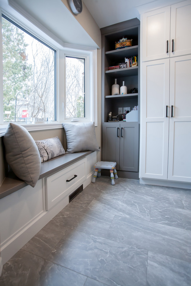 Mid-sized transitional l-shaped gray floor enclosed kitchen photo with an undermount sink, shaker cabinets, white cabinets, quartz countertops, gray backsplash, ceramic backsplash, stainless steel appliances, an island and white countertops