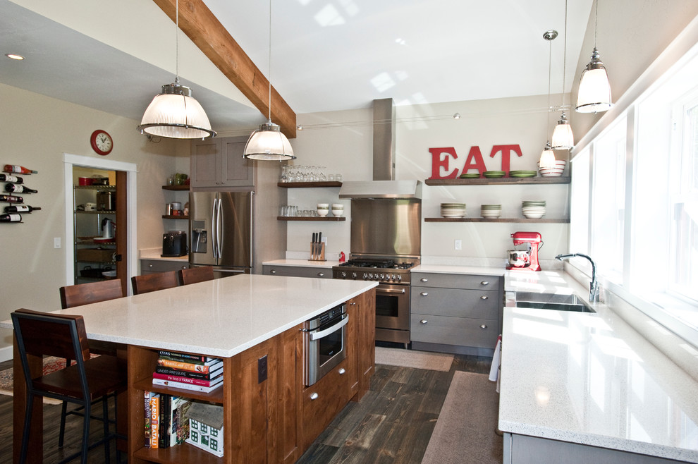 Example of a large transitional l-shaped dark wood floor and brown floor open concept kitchen design with a farmhouse sink, gray cabinets, quartz countertops, stainless steel appliances, an island and flat-panel cabinets
