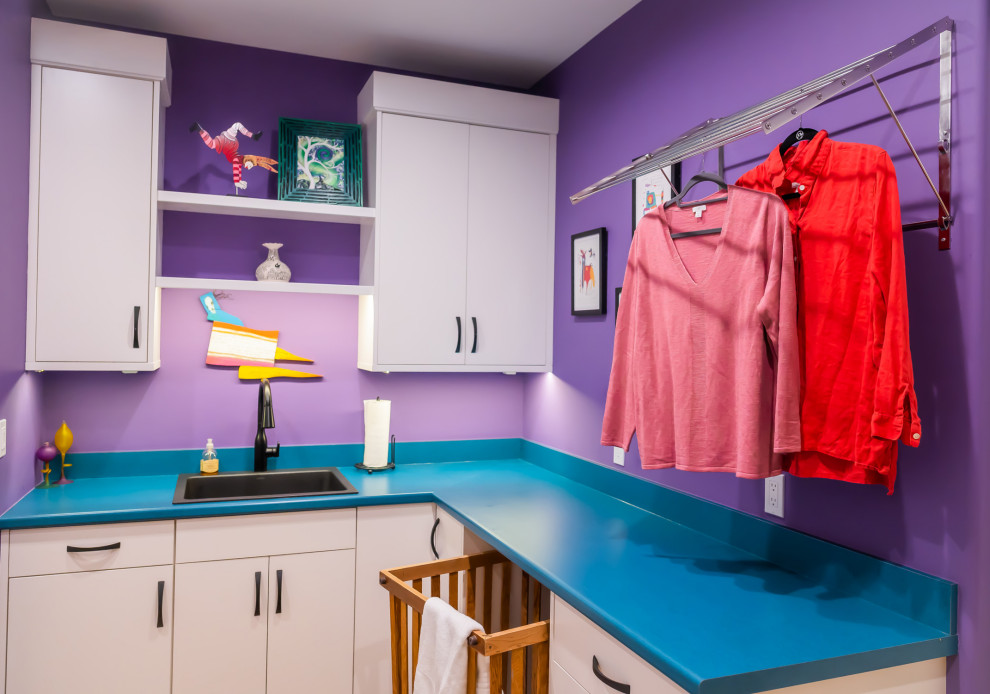 Exemple d'une buanderie moderne en L de taille moyenne avec un placard, un placard à porte plane, des portes de placard blanches, un plan de travail en quartz modifié, un mur violet, un plan de travail bleu et un évier posé.
