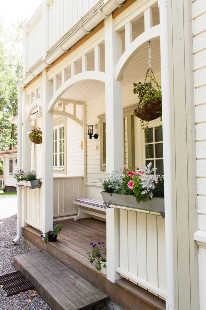 Inspiration for a mid-sized traditional front yard verandah in Stockholm with decking.