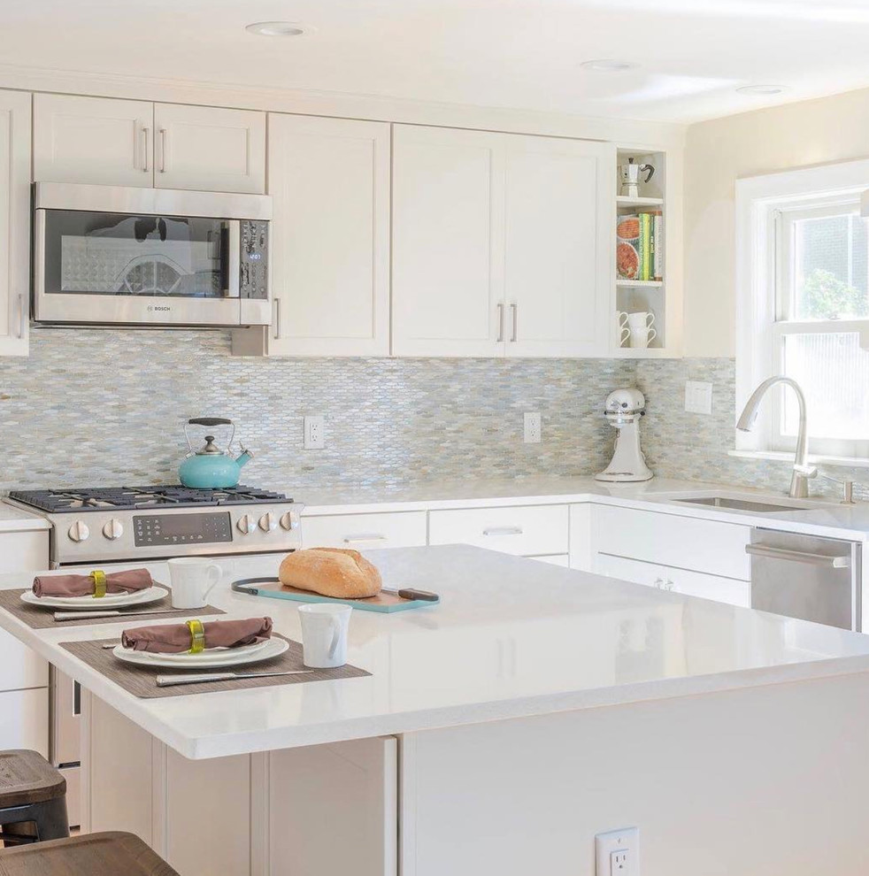 Example of a mid-sized transitional l-shaped kitchen design with beaded inset cabinets, white cabinets and an island