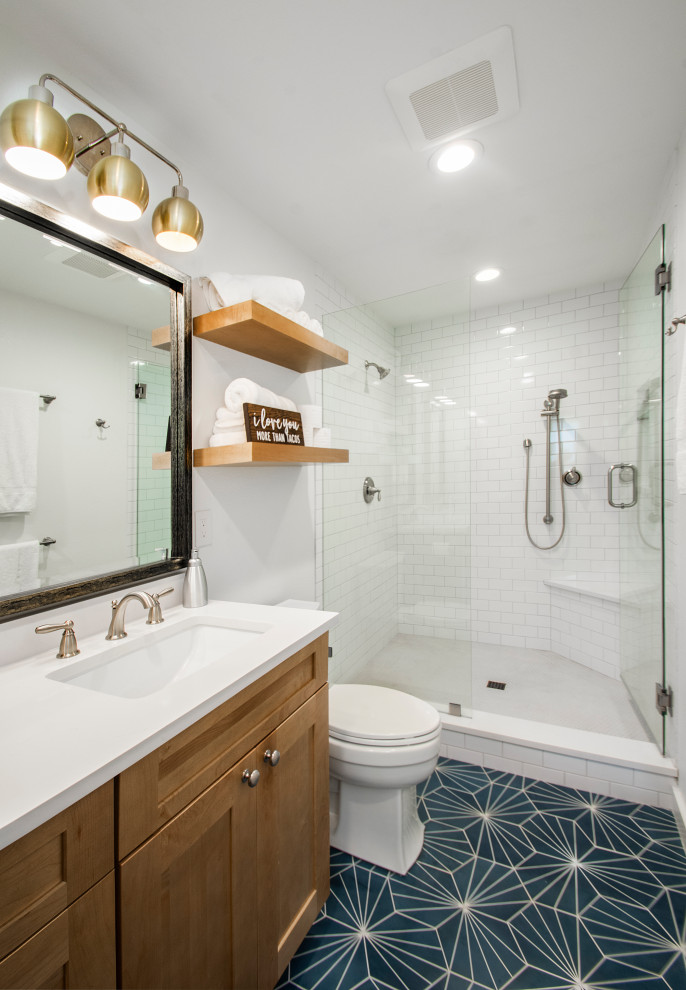 Photo of a mid-sized transitional kids bathroom in Dallas with flat-panel cabinets, brown cabinets, a double shower, a two-piece toilet, white tile, ceramic tile, white walls, porcelain floors, an undermount sink, engineered quartz benchtops, multi-coloured floor, a hinged shower door and white benchtops.