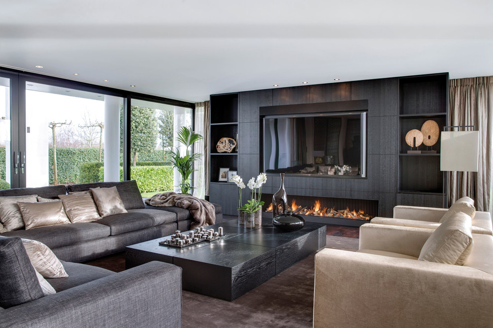 Contemporary living room in Amsterdam with a ribbon fireplace and a built-in media wall.
