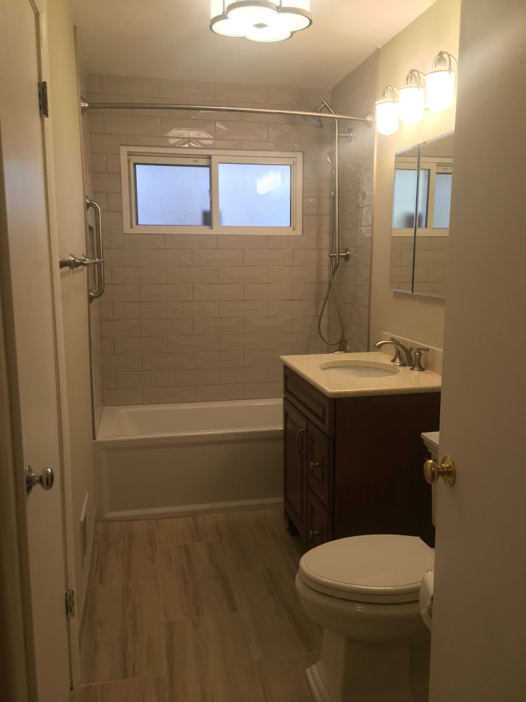 Idéer för ett mellanstort retro gul en-suite badrum, med luckor med upphöjd panel, skåp i mörkt trä, ett badkar i en alkov, en dusch/badkar-kombination, en toalettstol med separat cisternkåpa, grå kakel, tunnelbanekakel, grå väggar, klinkergolv i porslin, ett undermonterad handfat, bänkskiva i kvarts, flerfärgat golv och dusch med duschdraperi