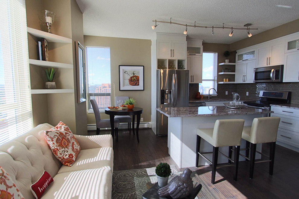Large l-shaped medium tone wood floor kitchen photo in Calgary with white backsplash, stainless steel appliances, an island, beaded inset cabinets, white cabinets and granite countertops