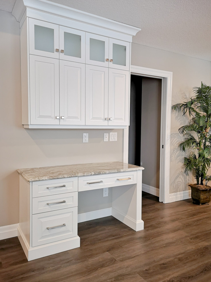 Mid-sized transitional u-shaped light wood floor and brown floor enclosed kitchen photo in Toronto with an undermount sink, raised-panel cabinets, white cabinets, granite countertops, beige backsplash, glass tile backsplash, stainless steel appliances, a peninsula and gray countertops