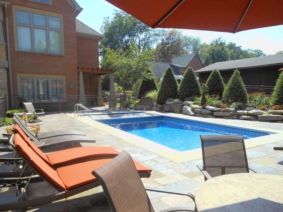 Large transitional backyard stone and rectangular lap pool photo