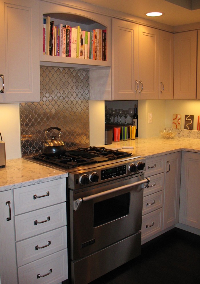 Example of a transitional l-shaped dark wood floor eat-in kitchen design in Boston with recessed-panel cabinets, white cabinets, quartz countertops, metallic backsplash, metal backsplash, stainless steel appliances and no island