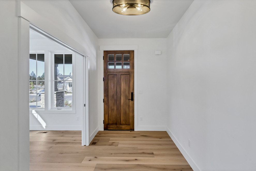 This is an example of a mid-sized contemporary foyer in Other with white walls, medium hardwood floors, a single front door, a medium wood front door and beige floor.
