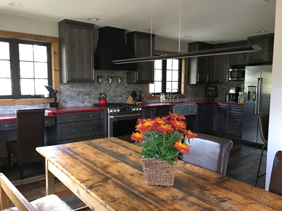 Mid-sized transitional l-shaped eat-in kitchen in Denver with a farmhouse sink, shaker cabinets, grey cabinets, quartz benchtops, grey splashback, stainless steel appliances, dark hardwood floors, no island and red benchtop.
