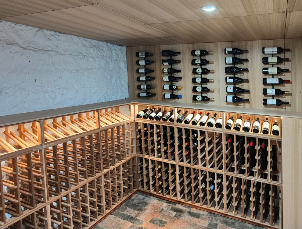 Aménagement d'une cave à vin classique de taille moyenne avec un sol en brique, des casiers et un sol orange.