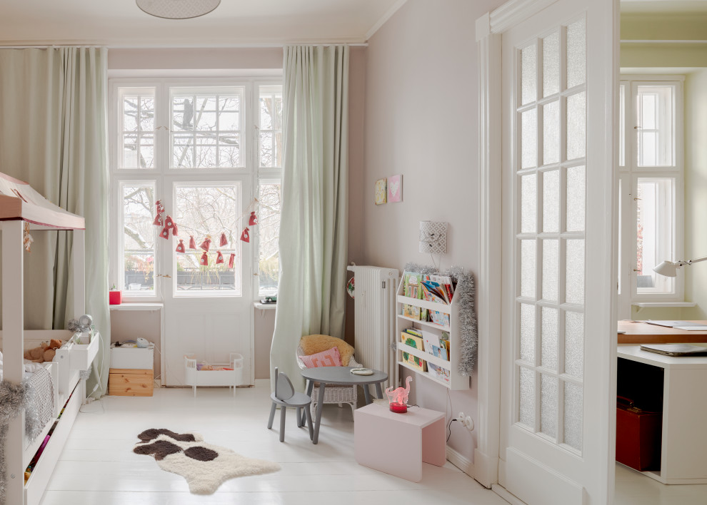 Scandinavian kids' room in Berlin with pink walls, light hardwood floors and white floor.