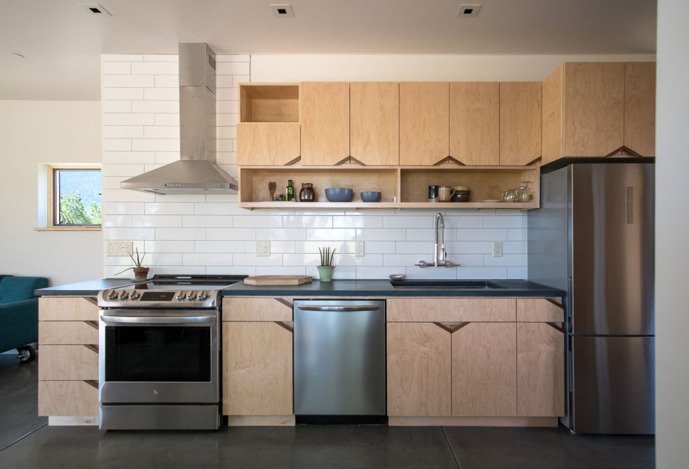 Design ideas for a small contemporary single-wall open plan kitchen in San Francisco with an undermount sink, flat-panel cabinets, light wood cabinets, concrete benchtops, white splashback, subway tile splashback, stainless steel appliances, concrete floors, no island, blue floor and blue benchtop.
