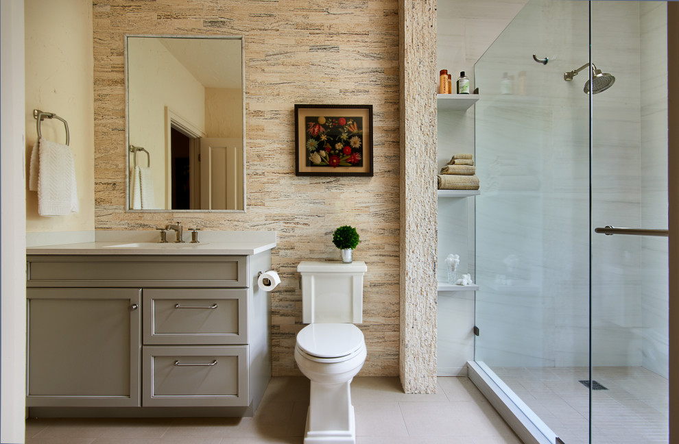 На фото: ванная комната в современном стиле с плоскими фасадами, фасадами цвета дерева среднего тона, угловым душем, унитазом-моноблоком, коричневой плиткой, цементной плиткой, бежевыми стенами, полом из керамической плитки, врезной раковиной, столешницей из искусственного кварца, белым полом, душем с распашными дверями, белой столешницей, тумбой под одну раковину, подвесной тумбой и панелями на стенах