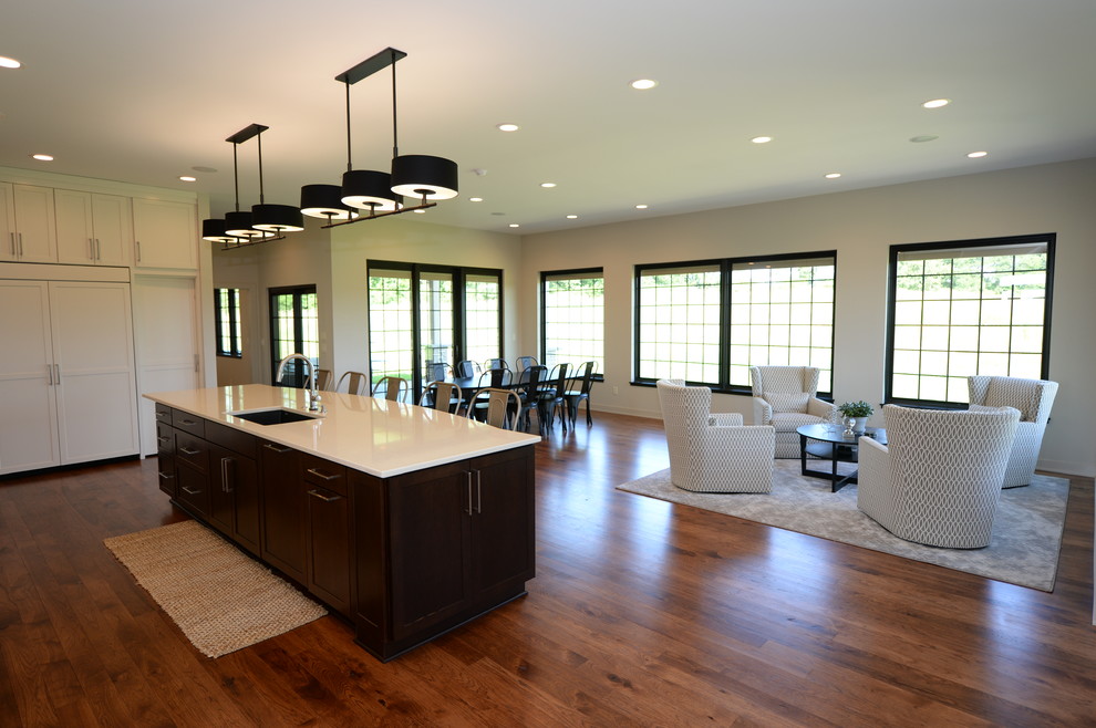 Inspiration for a large transitional single-wall medium tone wood floor open concept kitchen remodel with an undermount sink, recessed-panel cabinets, white cabinets, granite countertops, white backsplash, stainless steel appliances and an island