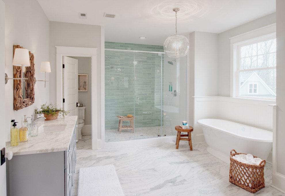 Inspiration for a transitional master bathroom in Richmond with grey cabinets, a freestanding tub, green tile, grey walls, marble floors, grey floor and an enclosed toilet.