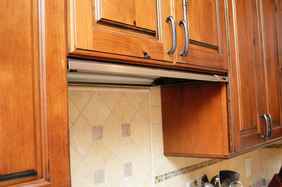 Kitchen - rustic kitchen idea in Orlando with raised-panel cabinets, distressed cabinets, granite countertops and stone tile backsplash