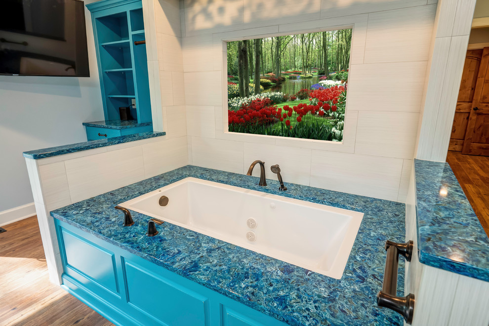 Large traditional master bathroom in Other with recessed-panel cabinets, turquoise cabinets, an alcove tub, blue tile, ceramic tile, medium hardwood floors, engineered quartz benchtops, brown floor, blue benchtops and grey walls.