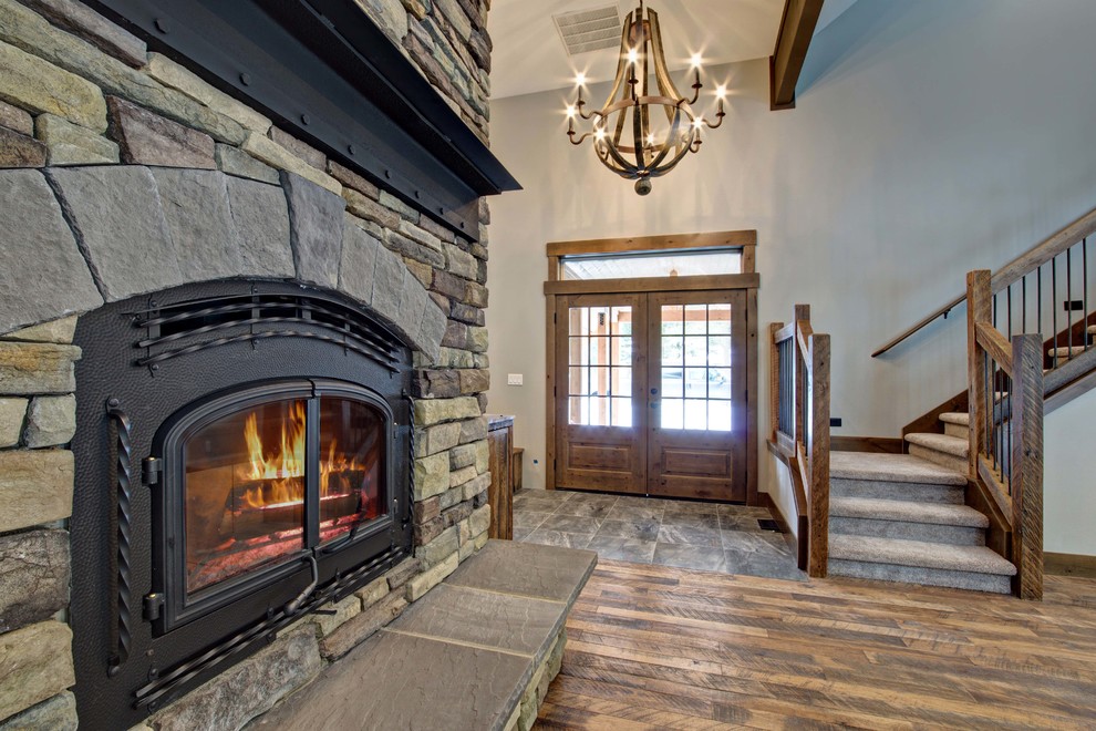 Home design - mid-sized rustic open concept medium tone wood floor home design idea in Seattle with gray walls, a wood stove and a stone fireplace