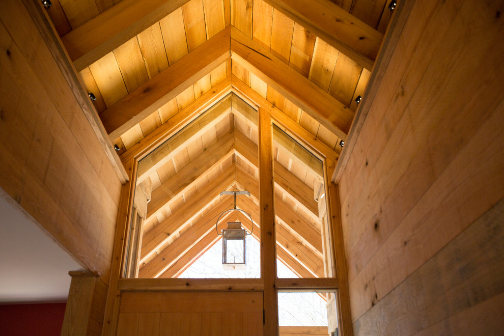 Example of a large mountain style ceramic tile foyer design with brown walls and a medium wood front door