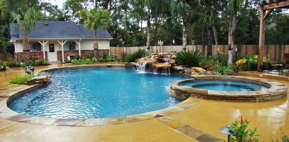 Inspiration for a large modern backyard custom-shaped pool in Houston with a water feature and stamped concrete.