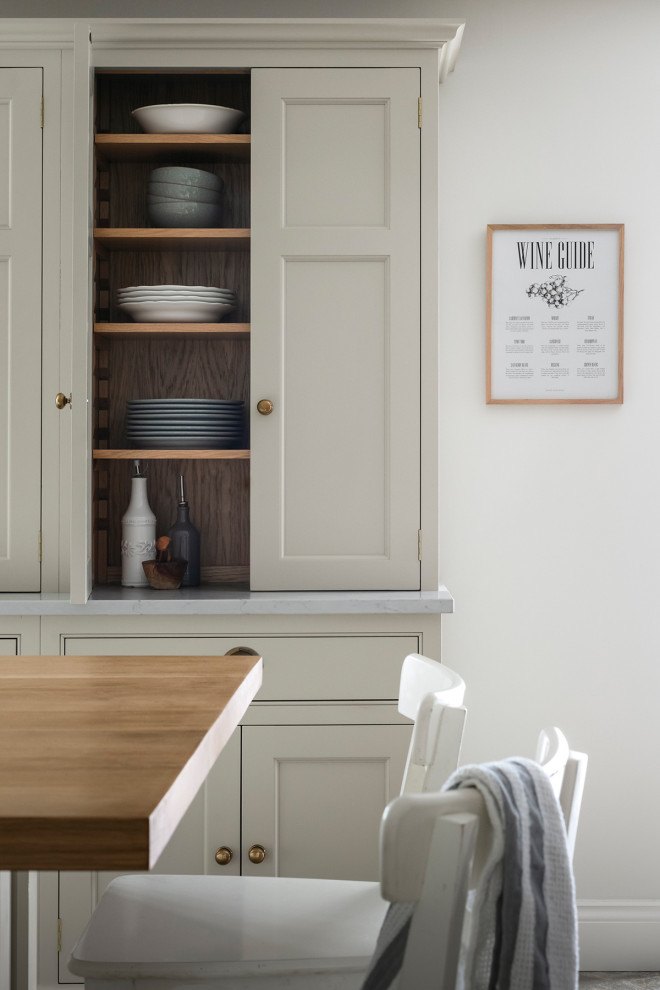 This is an example of a rural u-shaped kitchen/diner in Other with recessed-panel cabinets, beige cabinets, quartz worktops, stainless steel appliances, slate flooring, an island, beige worktops and a chimney breast.