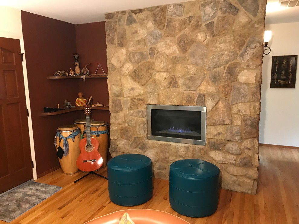 Inspiration for a mid-sized arts and crafts enclosed living room in Boise with a music area, white walls, medium hardwood floors, a standard fireplace, a stone fireplace surround, a wall-mounted tv and brown floor.