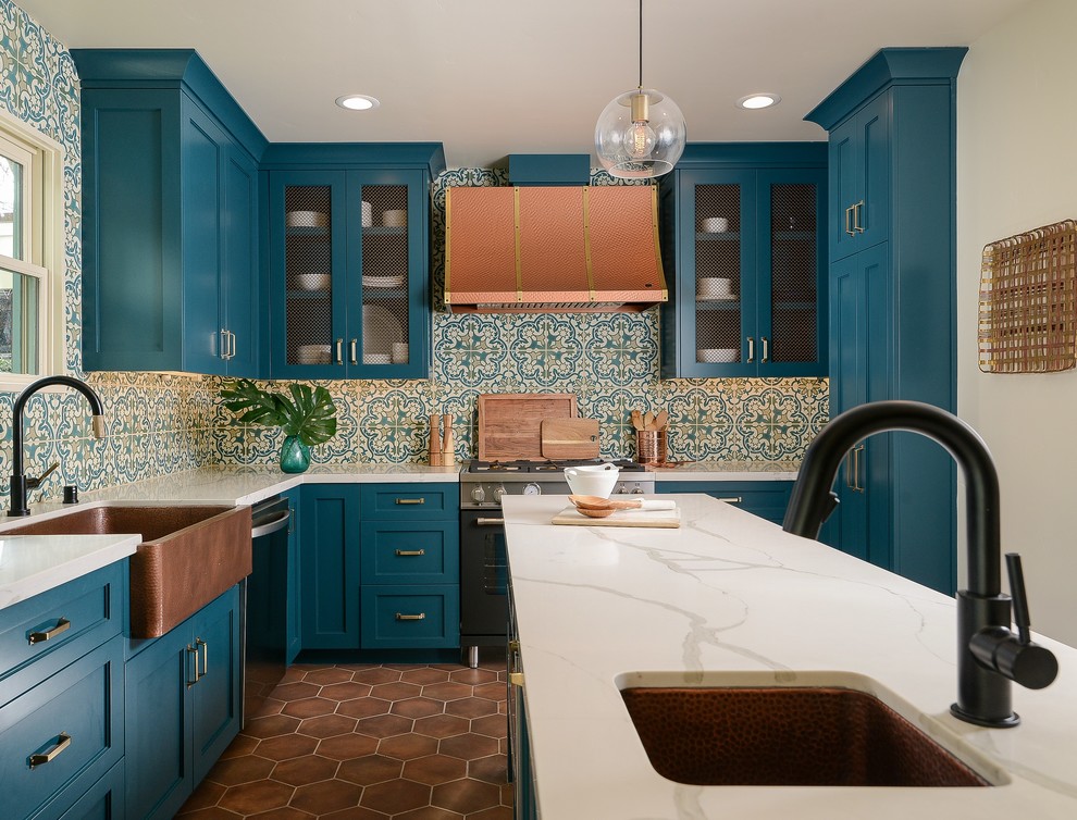 Photo of a mediterranean kitchen in Sacramento with shaker cabinets, turquoise cabinets, solid surface benchtops, terra-cotta floors, with island and white benchtop.