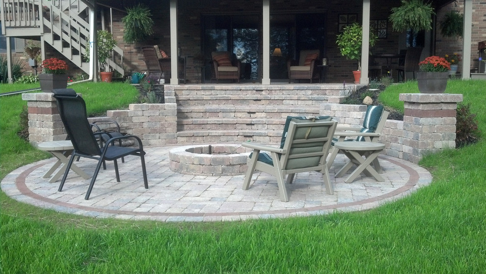 Inspiration for a mid-sized transitional backyard brick patio remodel with a fire pit and a roof extension