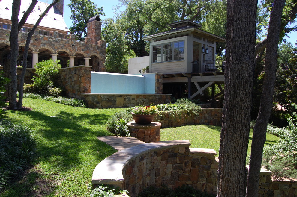 Inspiration for a traditional backyard garden in Dallas with a retaining wall.