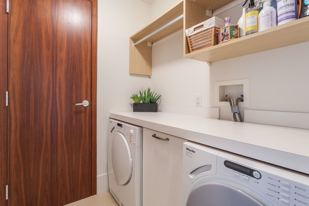 This is an example of a small contemporary single-wall dedicated laundry room in Vancouver with open cabinets, light wood cabinets, quartzite benchtops, white walls, a side-by-side washer and dryer and beige floor.