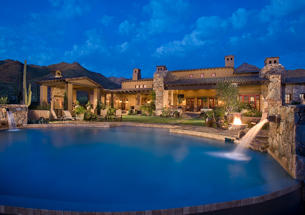 Large mediterranean round pool in Phoenix with natural stone pavers.