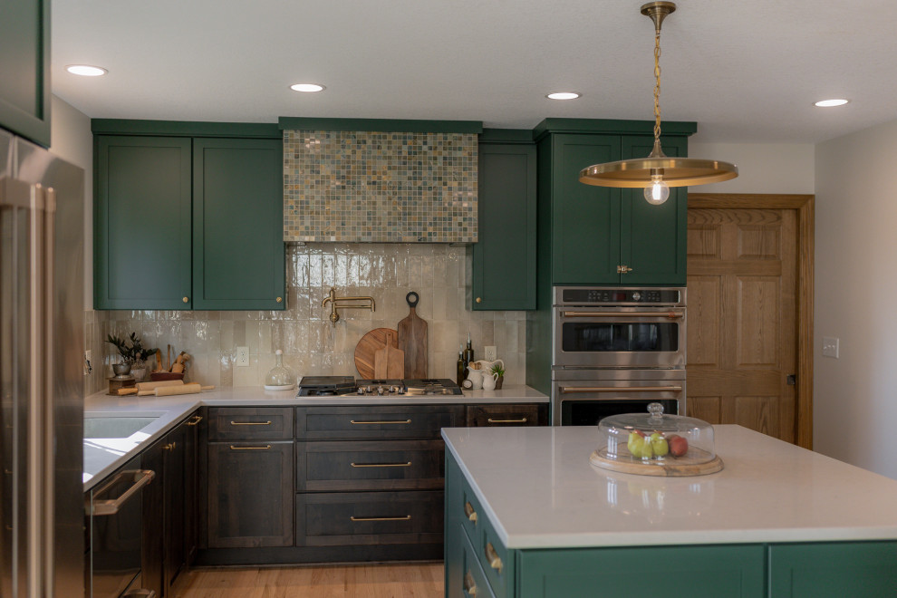 Inspiration for a mid-sized transitional l-shaped light wood floor and brown floor eat-in kitchen remodel with an undermount sink, recessed-panel cabinets, green cabinets, quartz countertops, beige backsplash, terra-cotta backsplash, stainless steel appliances, two islands and beige countertops
