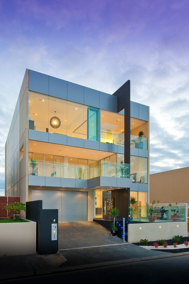 This is an example of a contemporary three-storey house exterior in Adelaide with metal siding and a flat roof.