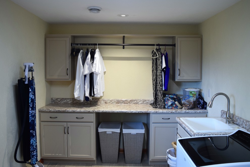Large traditional l-shaped dedicated laundry room in Other with a single-bowl sink, recessed-panel cabinets, grey cabinets, laminate benchtops, beige walls, porcelain floors, a side-by-side washer and dryer, brown floor and brown benchtop.