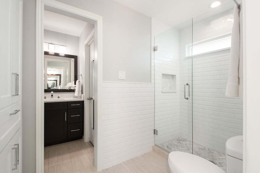 Small transitional master bathroom in Dallas with flat-panel cabinets, brown cabinets, white tile, ceramic tile, engineered quartz benchtops, white benchtops, a double shower, a two-piece toilet, white walls, an undermount sink, grey floor, a hinged shower door and light hardwood floors.
