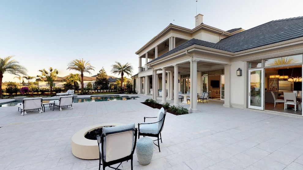 Large transitional two-storey stucco beige house exterior in Tampa with a hip roof and a tile roof.