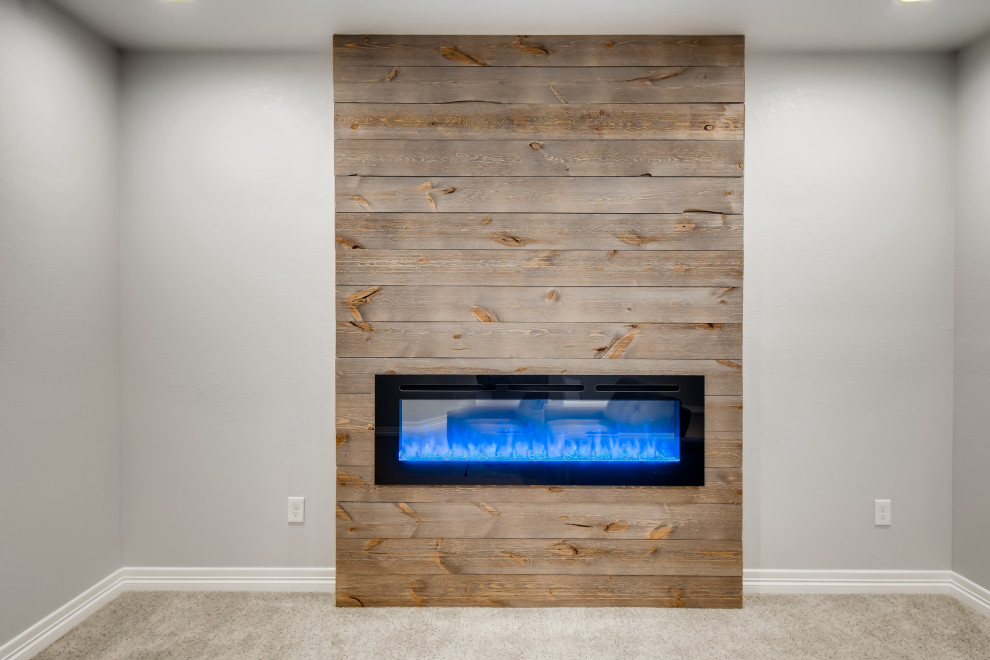 Example of a mid-sized trendy underground carpeted and gray floor basement design in Denver with gray walls and a shiplap fireplace