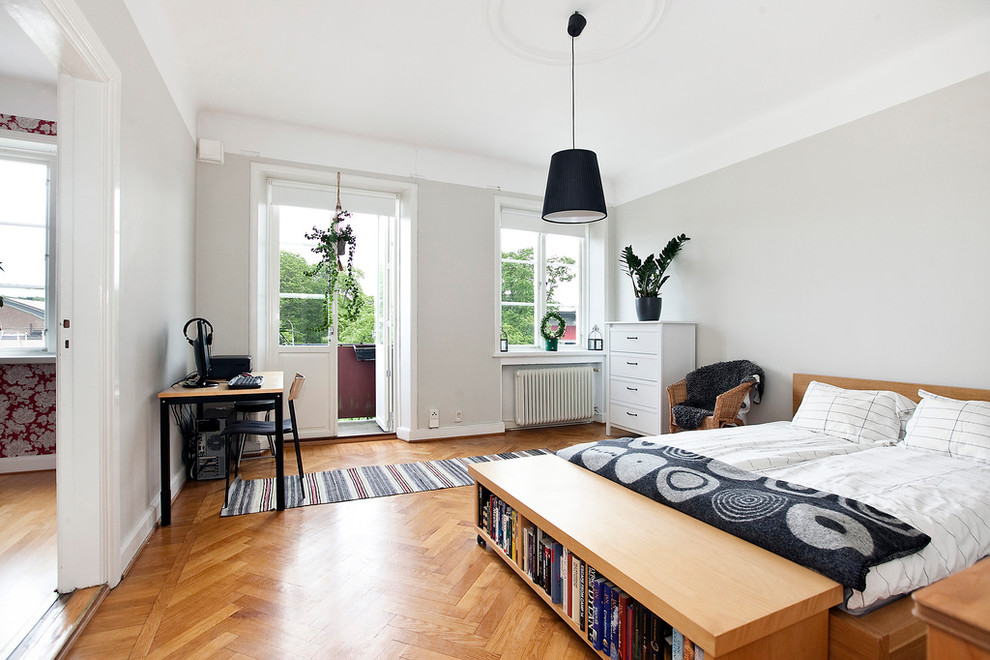 This is an example of a mid-sized contemporary master bedroom in Malmo with grey walls, light hardwood floors and no fireplace.