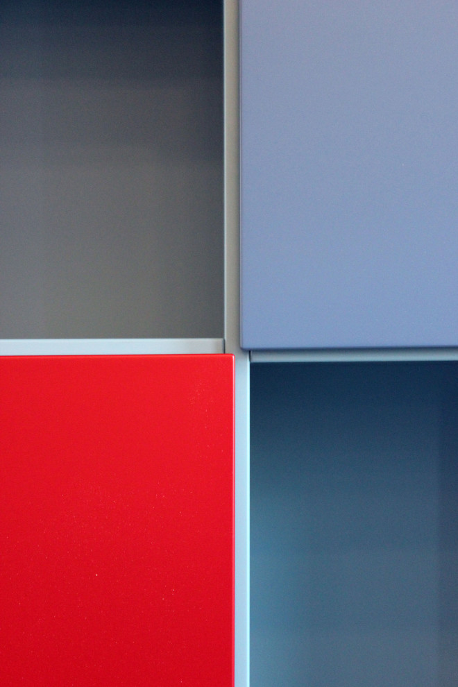 Modelo de armario unisex minimalista de tamaño medio con armarios con paneles lisos, puertas de armario azules, suelo de madera clara y bandeja