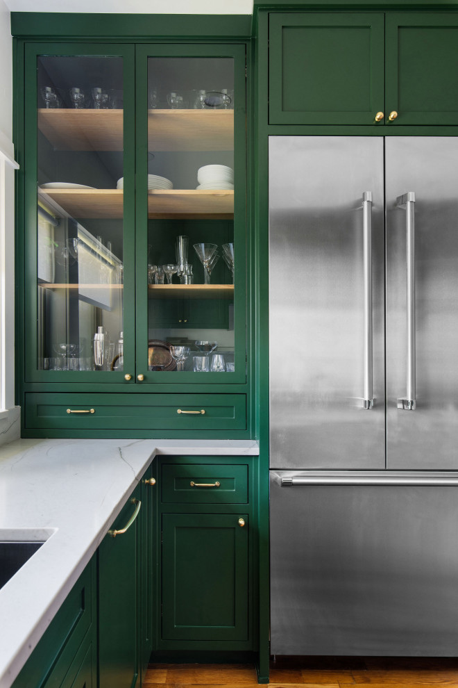 Example of a mid-sized transitional u-shaped medium tone wood floor and brown floor home bar design in Austin with an undermount sink, shaker cabinets, green cabinets, quartzite countertops, white backsplash, stone slab backsplash and white countertops