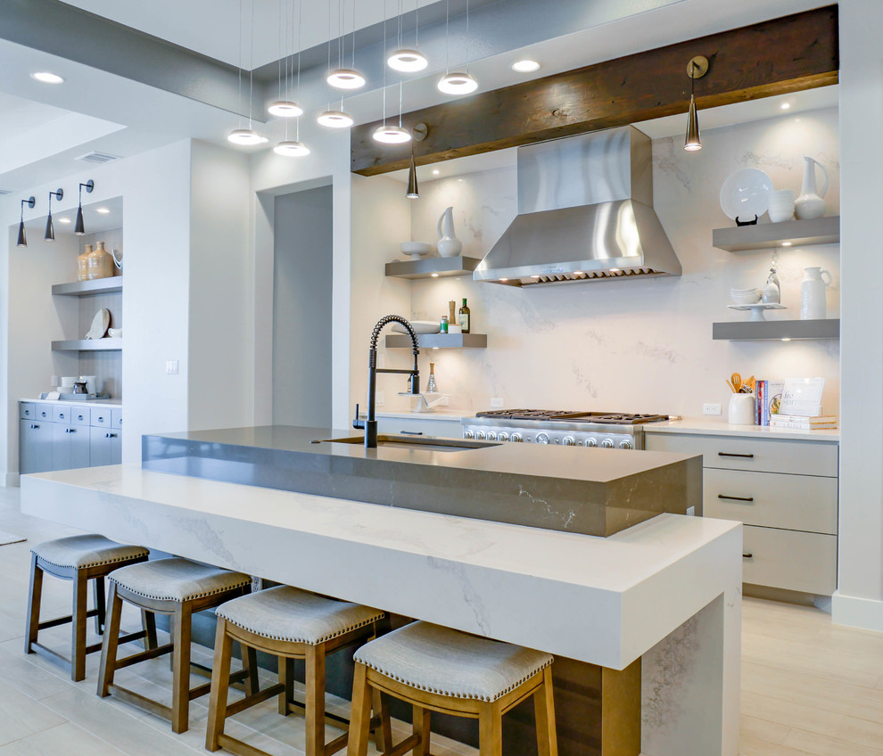 Design ideas for an expansive contemporary single-wall kitchen in Austin with quartz benchtops, white splashback, light hardwood floors, an undermount sink, flat-panel cabinets, beige cabinets, stone slab splashback, with island, beige floor and white benchtop.