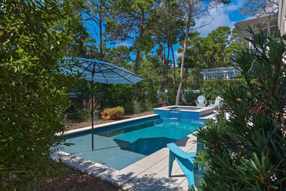 Photo of a small traditional backyard rectangular pool in Miami with a hot tub and concrete pavers.