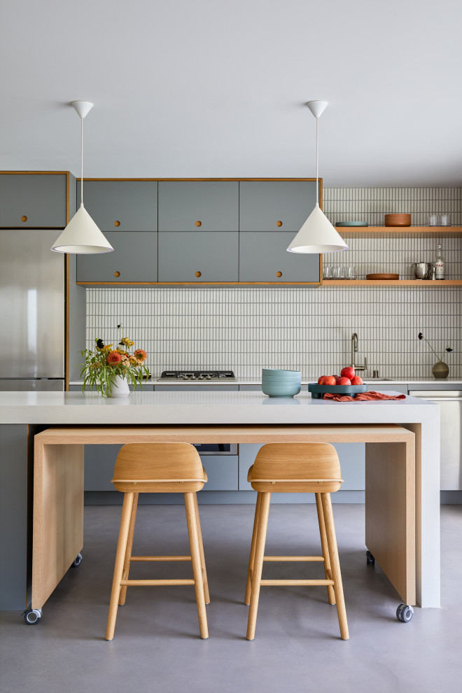 Exempel på ett mellanstort modernt grå linjärt grått kök med öppen planlösning, med en undermonterad diskho, släta luckor, grå skåp, bänkskiva i kvarts, vitt stänkskydd, stänkskydd i keramik, rostfria vitvaror, betonggolv, en köksö och grått golv