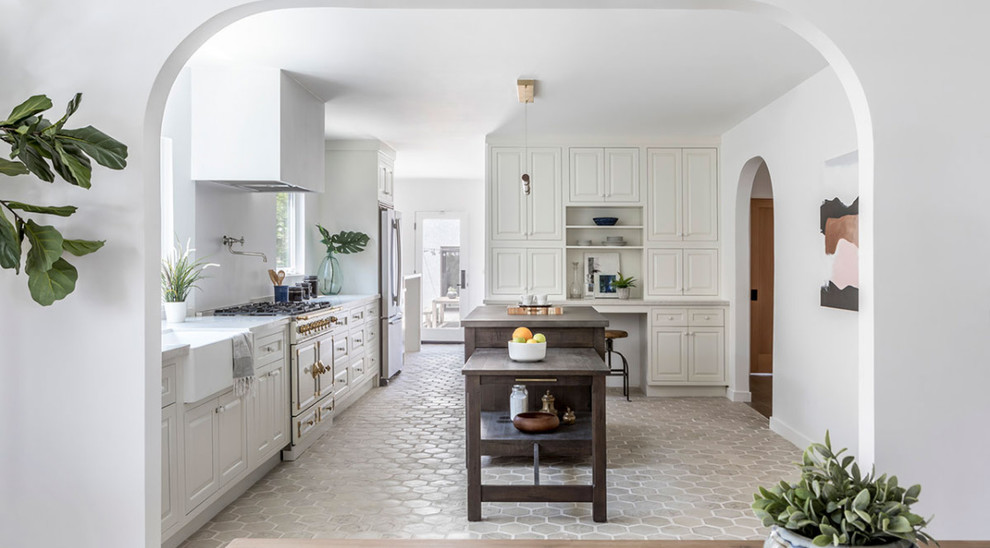 This is an example of a large scandinavian galley separate kitchen in San Francisco with a farmhouse sink, raised-panel cabinets, white cabinets, marble benchtops, stainless steel appliances, terra-cotta floors, with island, beige floor and white benchtop.