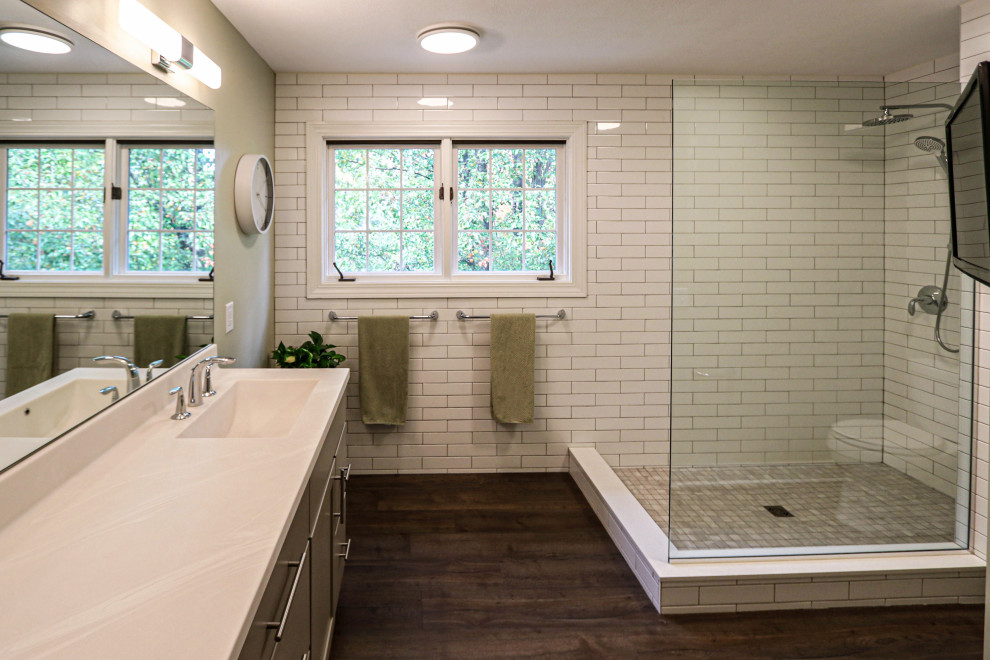 Mid-sized transitional master bathroom in Cleveland with flat-panel cabinets, grey cabinets, a corner shower, a two-piece toilet, white tile, green walls, laminate floors, an integrated sink, solid surface benchtops, blue floor, an open shower, beige benchtops, a double vanity and a freestanding vanity.